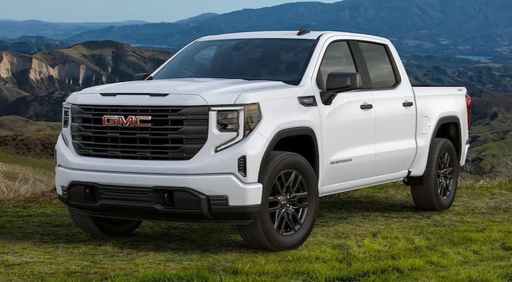 A white 2024 GMC Sierra 1500 SLE is shown parked on grass after visiting a GMC dealer near Humboldt.