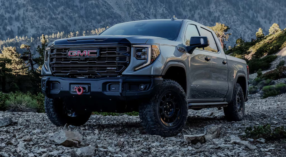 A grey 2024 GMC Sierra 1500 AT4X parked on a rocky mountainside.