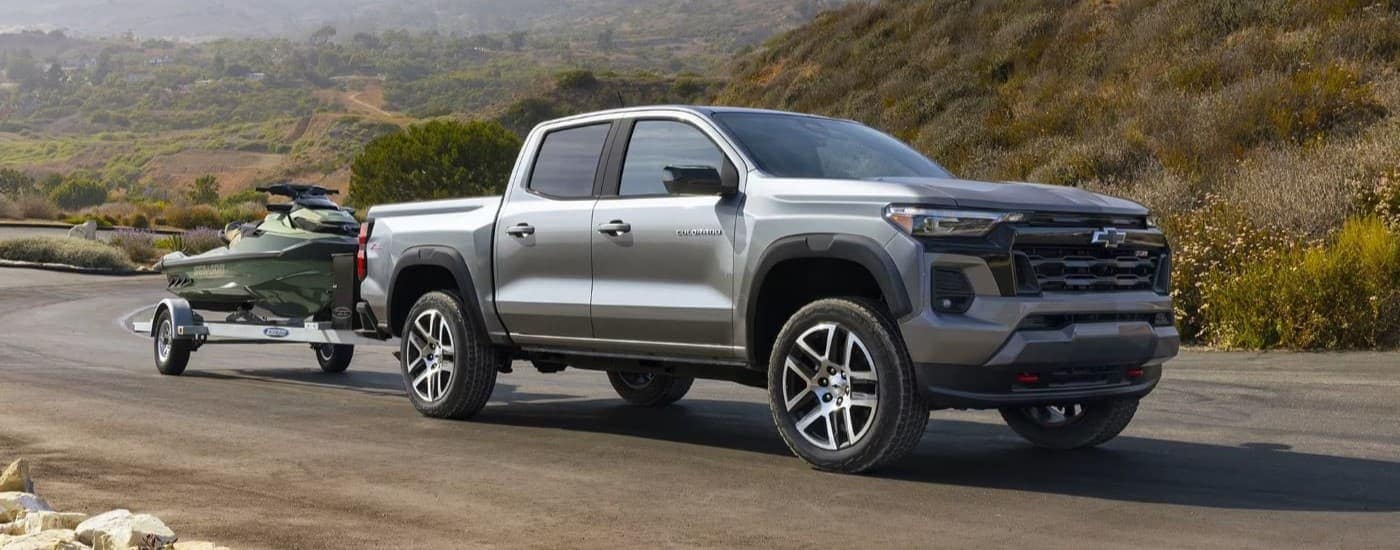 A grey 2023 Chevy Colorado Z71 is shown towing a jetski.