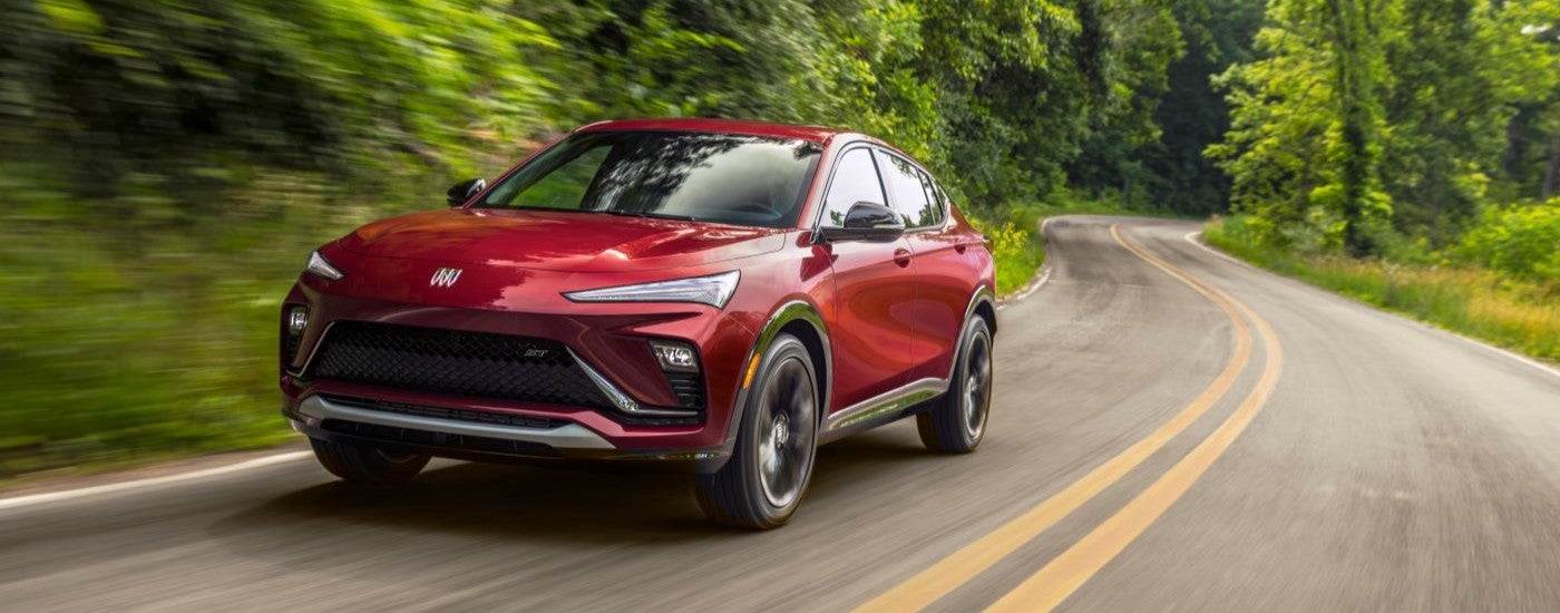 A red 2024 Buick Envista ST driving from a Buick dealer near Gowrie.