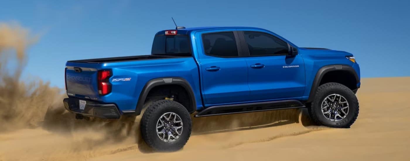 A blue 2024 Chevy Colorado ZR2 is shown driving off-road.