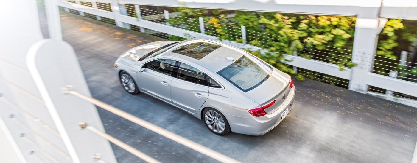 A silver 2017 Buick LaCrosse is shown driving over a bridge after leaving a Buick dealer.
