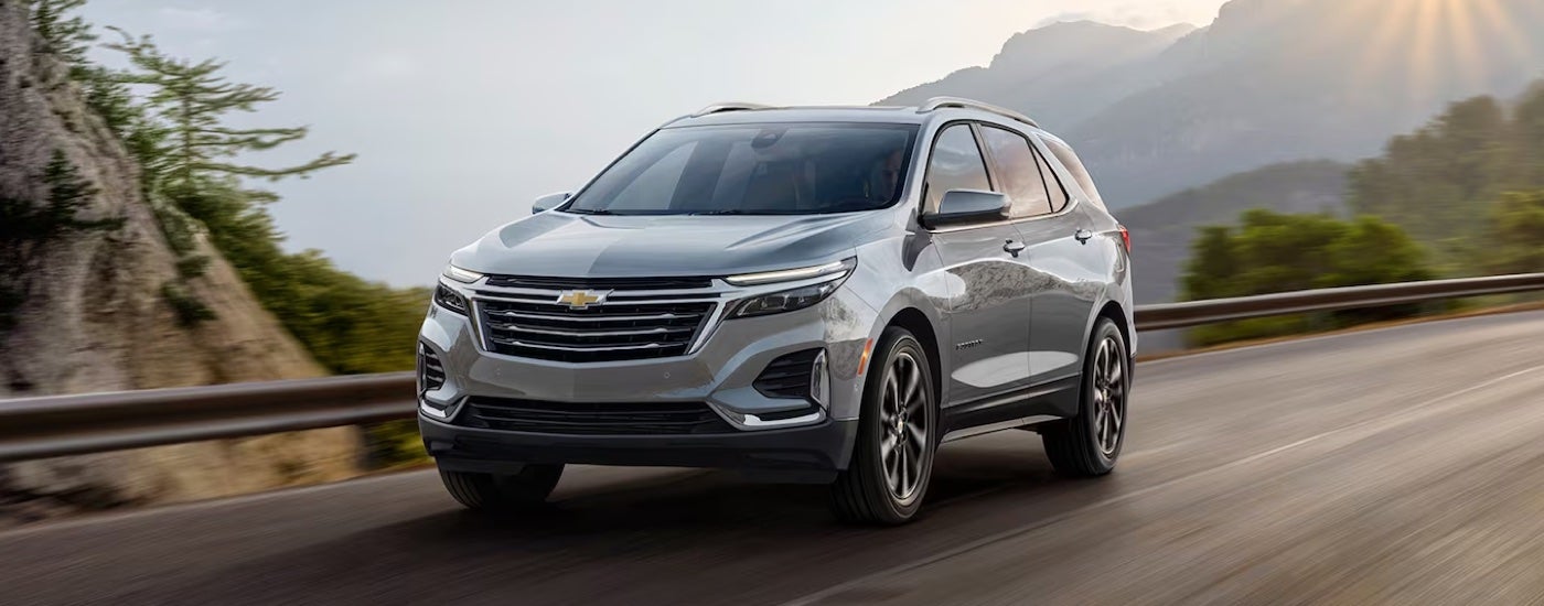 A silver 2024 Chevy Equinox Premier driving to a Chevy dealer near Webster City.