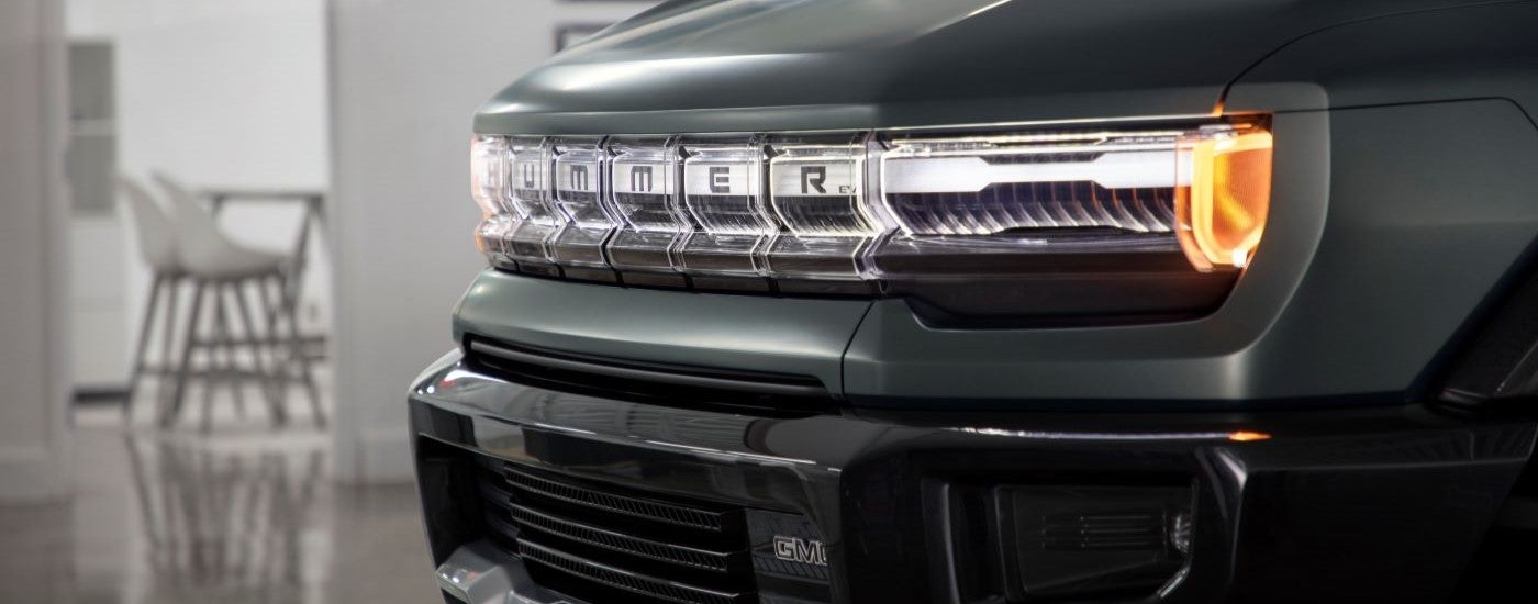 A close up shows the grille on a green 2024 GMC Hummer EV at a GMC dealer.