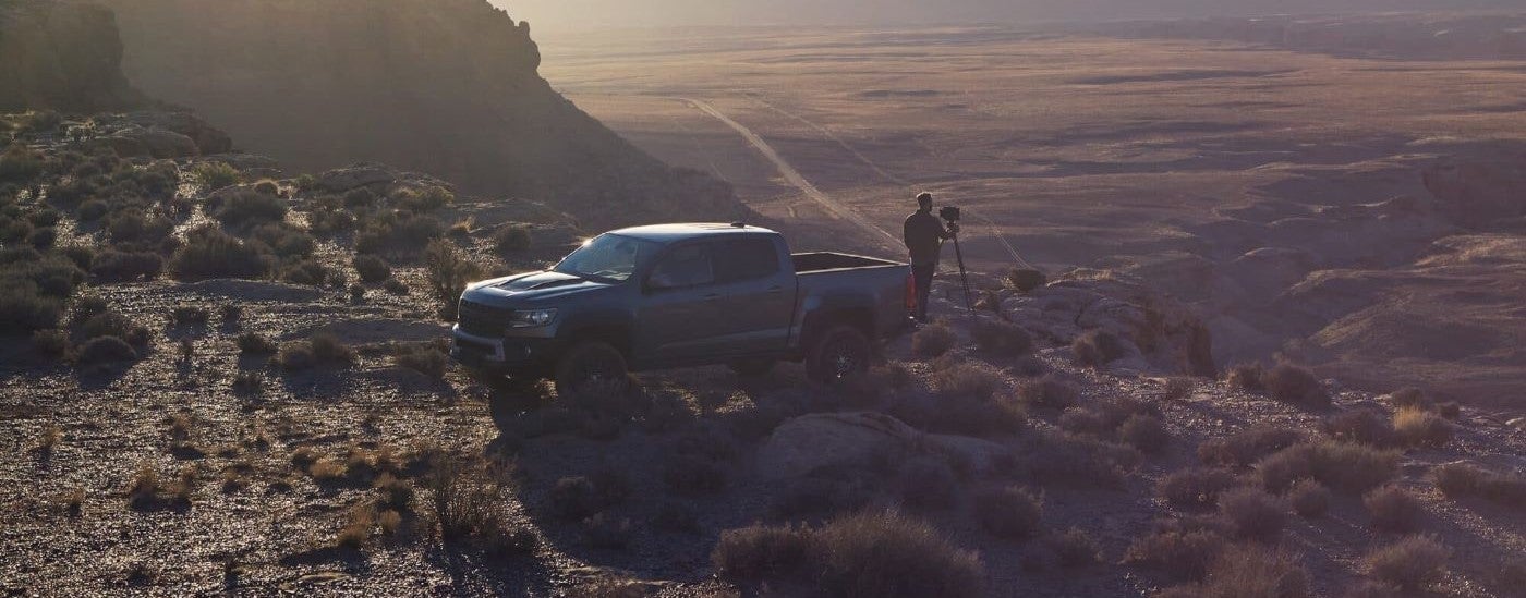 A photographer is shown taking pictures next to a grey 2021 Chevy Colorado ZR2.
